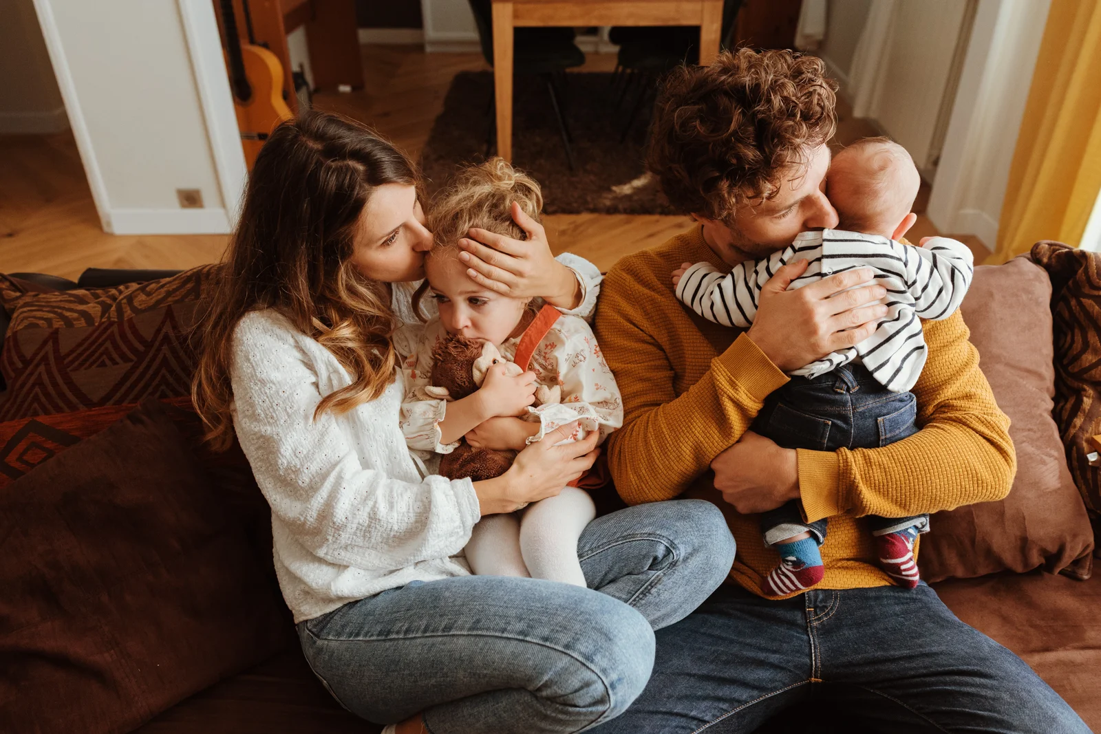 Portrait de famille avec un bébé et une grande sœur pendant une séance photo à domicile
