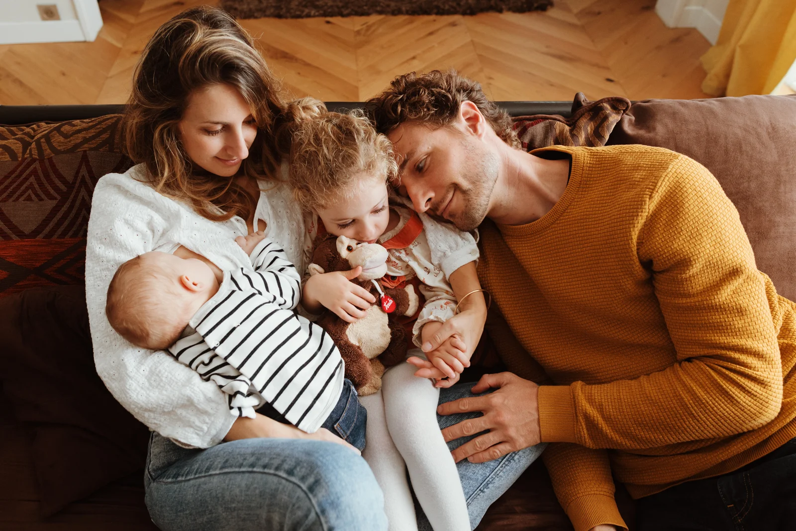Moment de tendresse en famille pendant une séance photo avec bébé à domicile