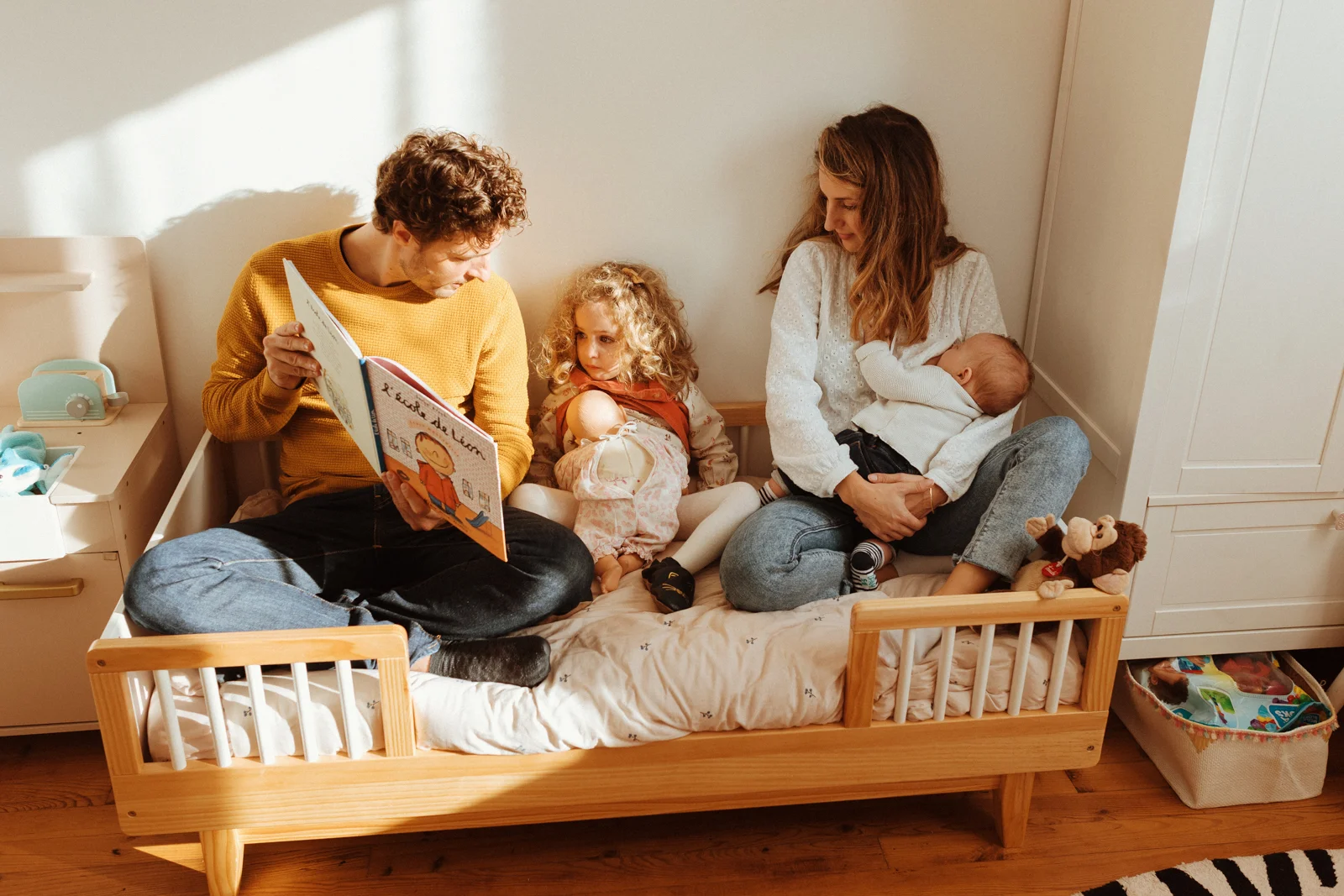 Séance photo nouveau-né et allaitement à Dax avec une famille lisant une histoire à leur fille