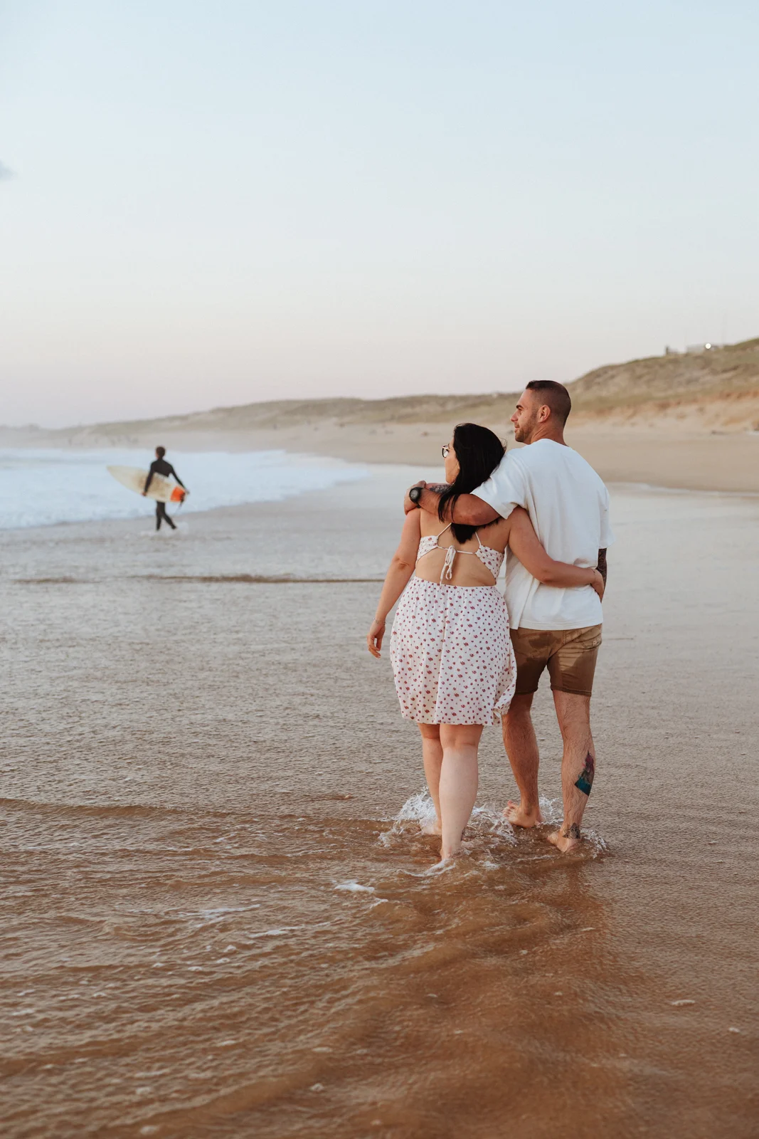 Couple marchant pieds nus sur la plage pendant une séance photo dans les Landes