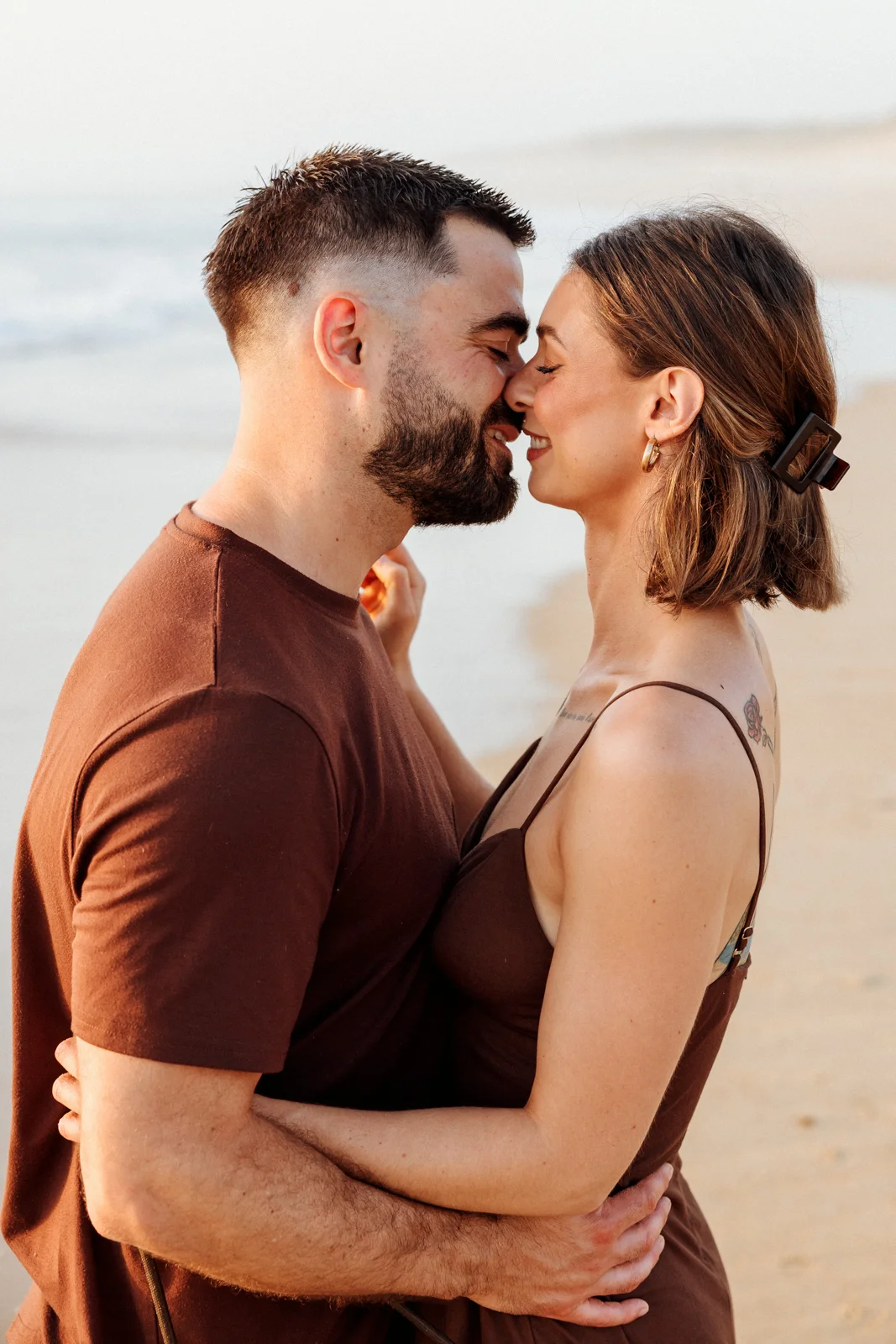 Couple enlacé sur la plage au coucher du soleil dans les Landes