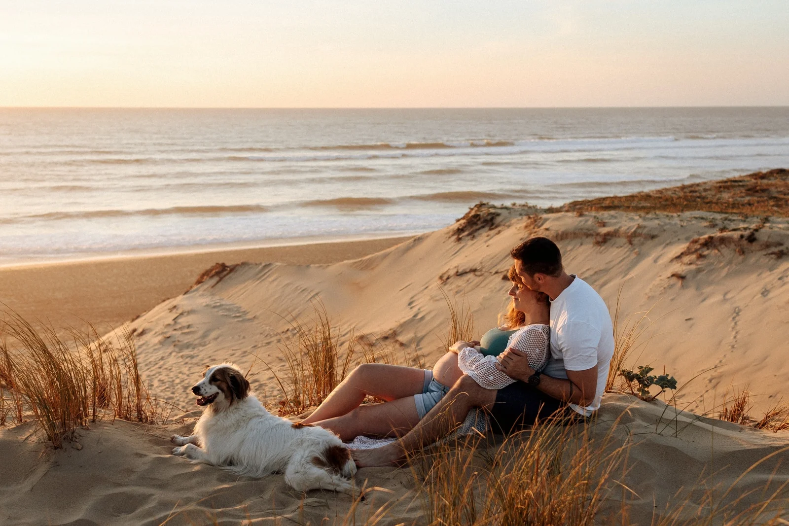 Couple attendant un bébé avec leur chien sur la plage des Landes