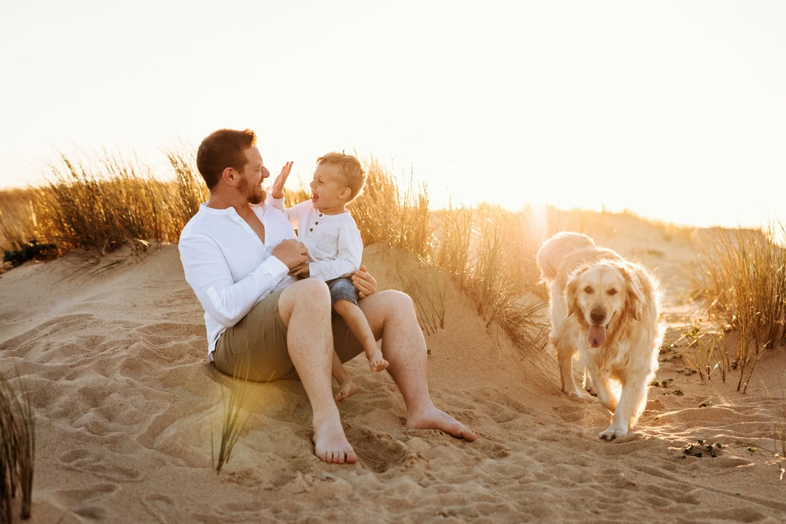 famille avec leur chien dans les dunes au coucher du soleil lors d’une séance photo dans les Landes