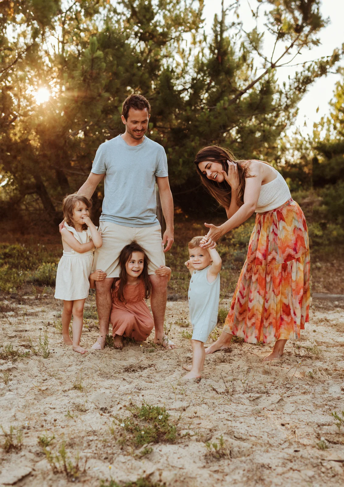 famille avec trois enfants jouant ensemble dans la nature lors d’une séance photo dans les Landes