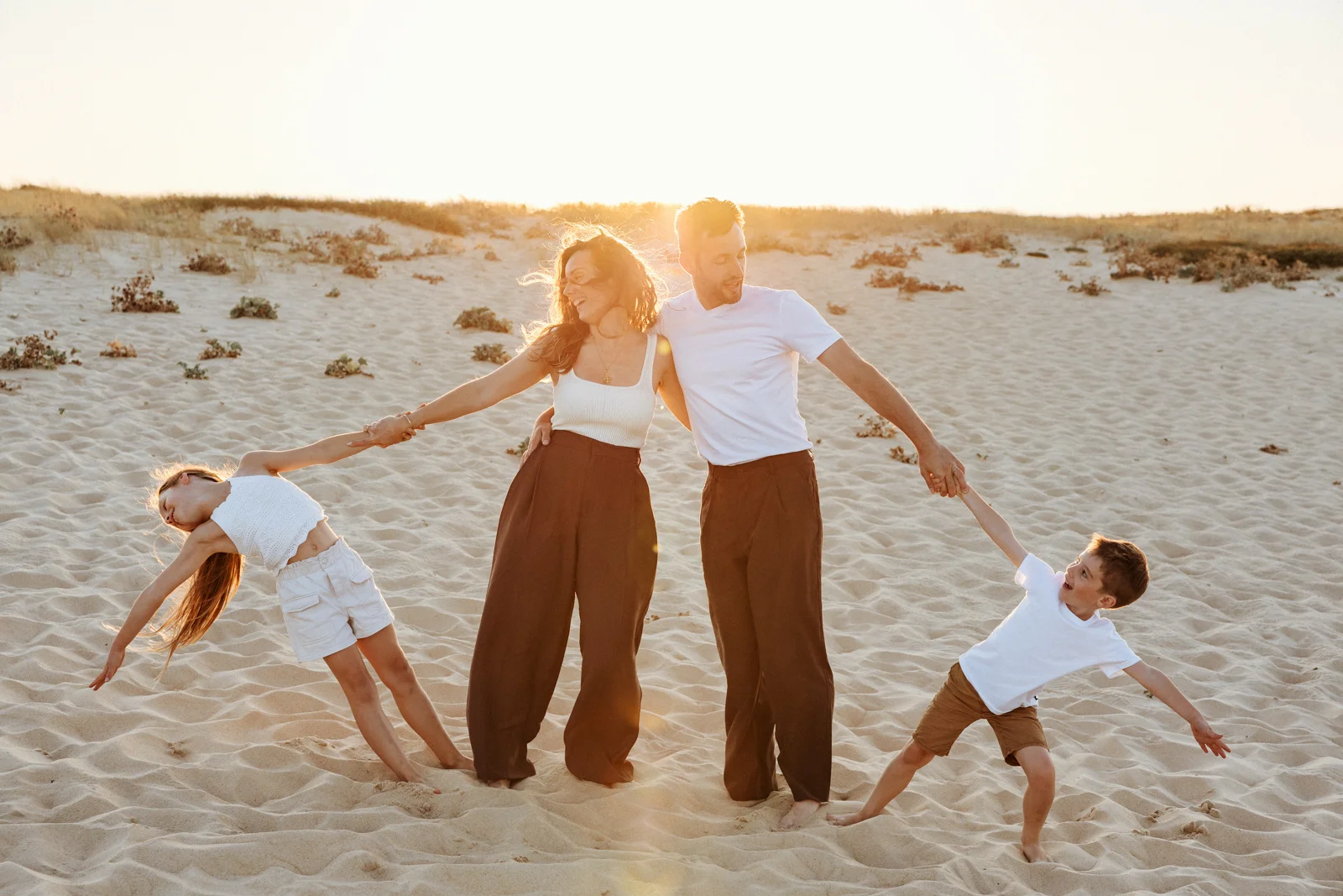 famille qui joue avec ses enfants sur la plage au coucher de soleil lors d’une séance photo dans les Landes