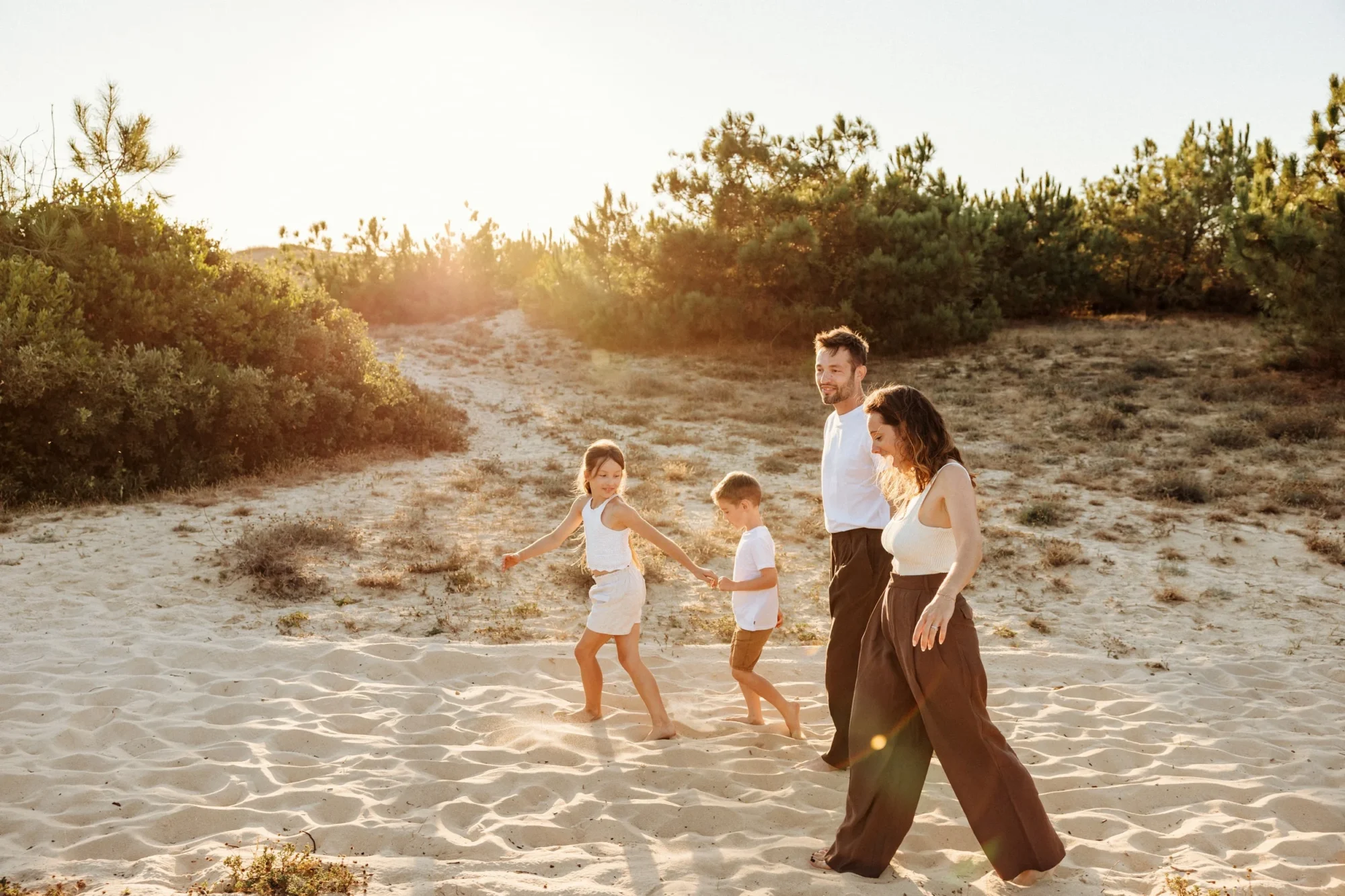 famille marchant sur la plage au coucher du soleil lors d’une séance photo dans les Landes
