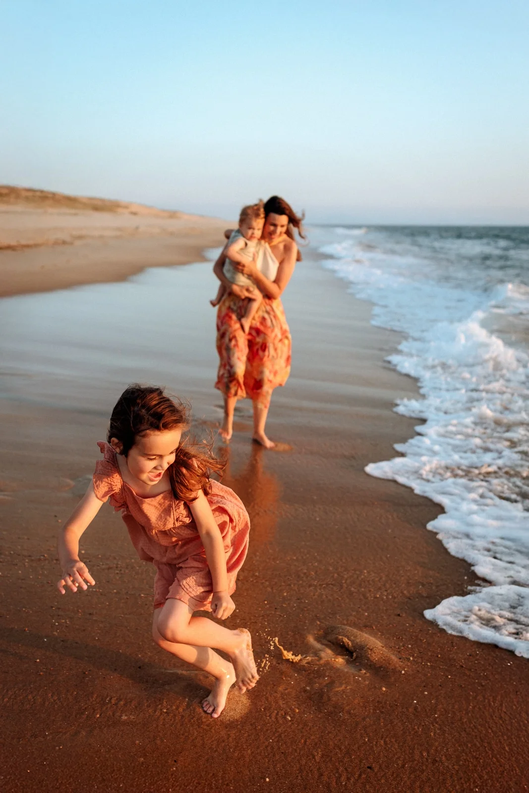 enfant courant sur la plage lors d’une séance photo famille dans les Landes au coucher de soleil