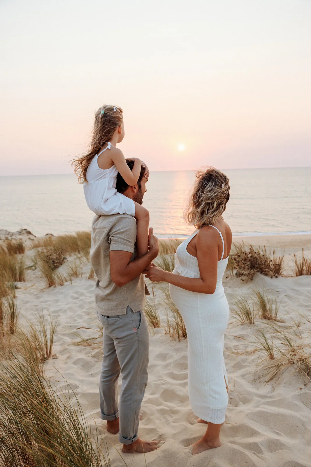 Séance photo grossesse à Capbreton au coucher du soleil sur la plage, en famille face à l’océan.