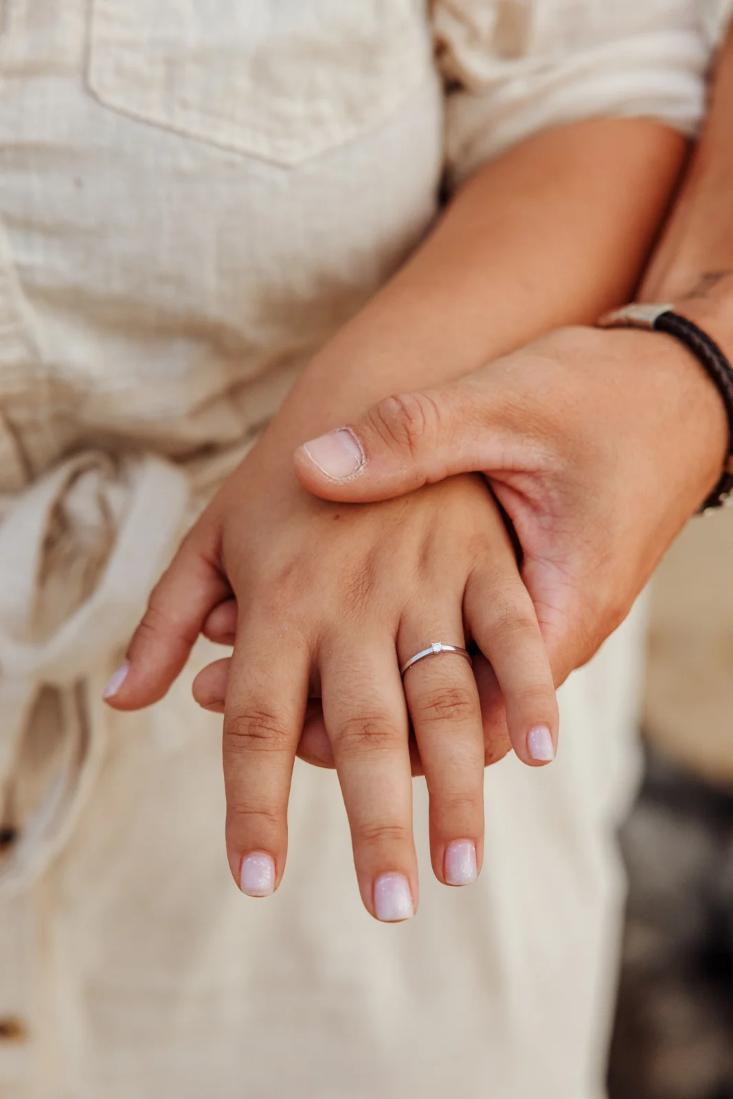 Bague de fiançailles photographiée sur la main après une demande en mariage sur la plage
