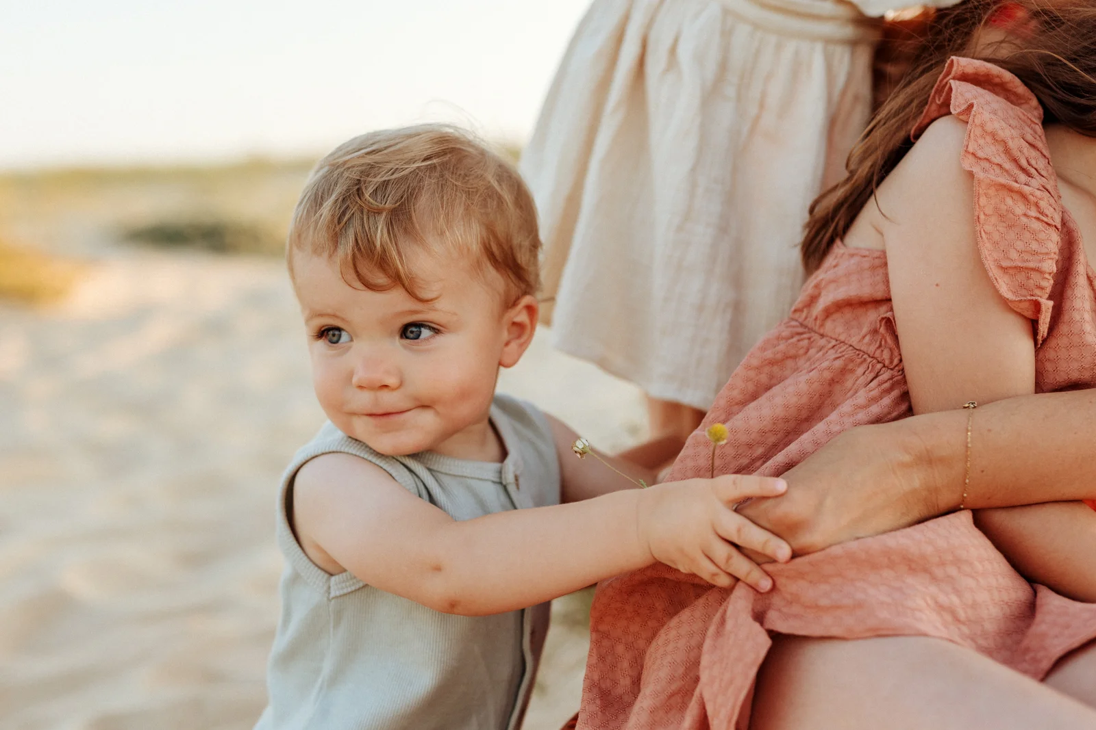 Bébé avec sa famille sur la plage au coucher du soleil pendant une séance photo dans les Landes