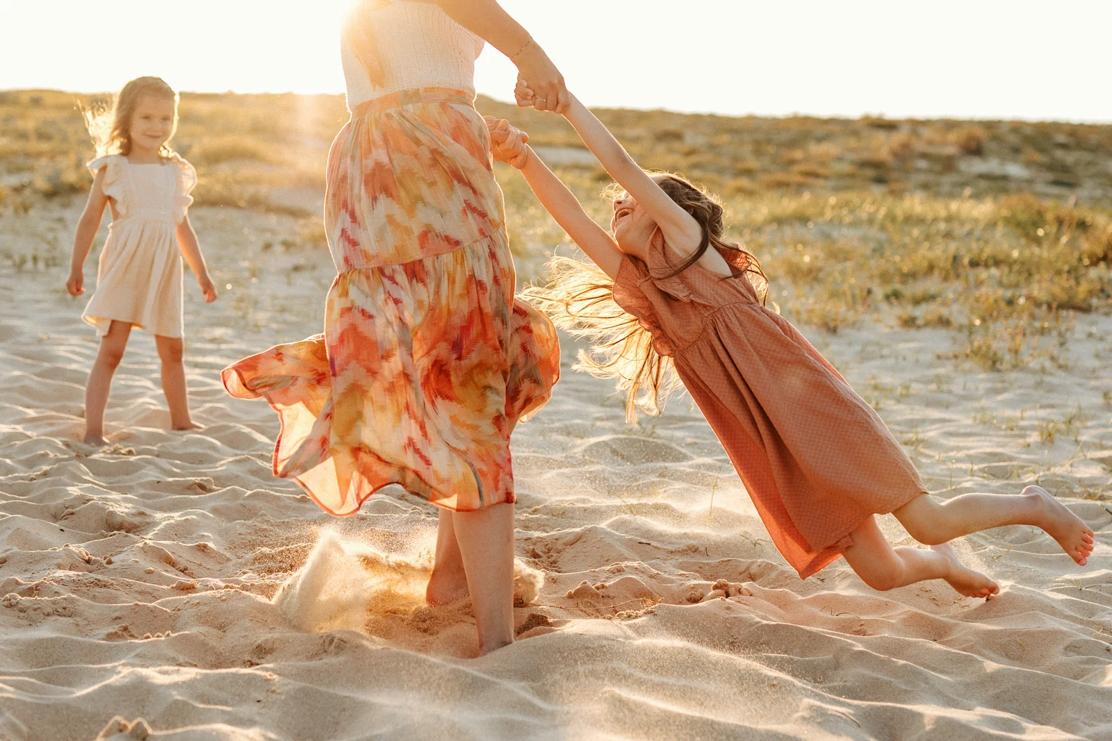 Enfant jouant dans le sable à la lumière dorée du coucher du soleil pendant une séance photo dans les Landes