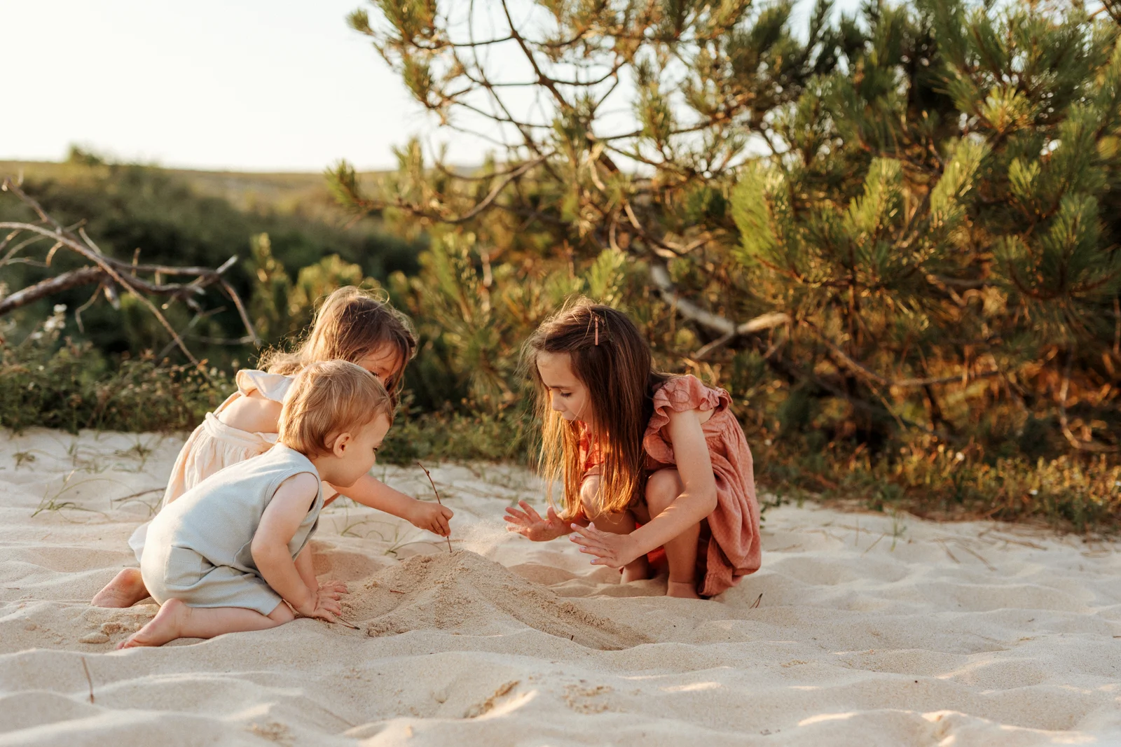 Enfants jouant dans le sable au coucher du soleil pendant une séance photo dans les Landes
