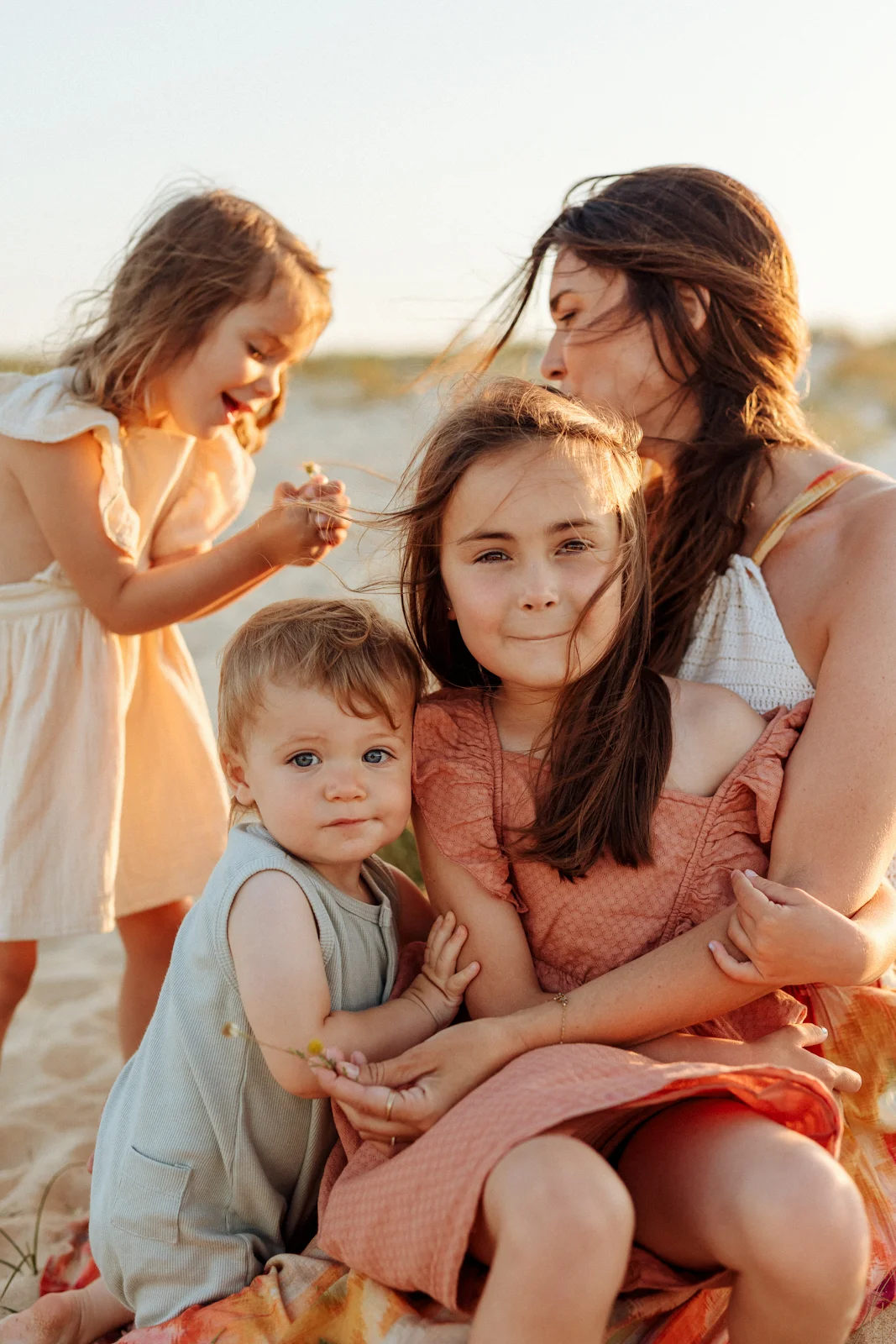 Fratrie avec leur maman au coucher du soleil pendant une séance photo dans les dunes des Landes
