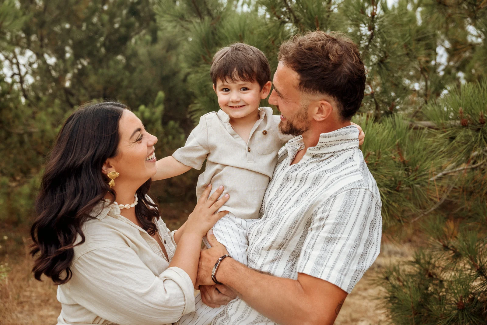 Parents avec leur petit garçon dans les bras lors d’une séance photo famille dans les Landes