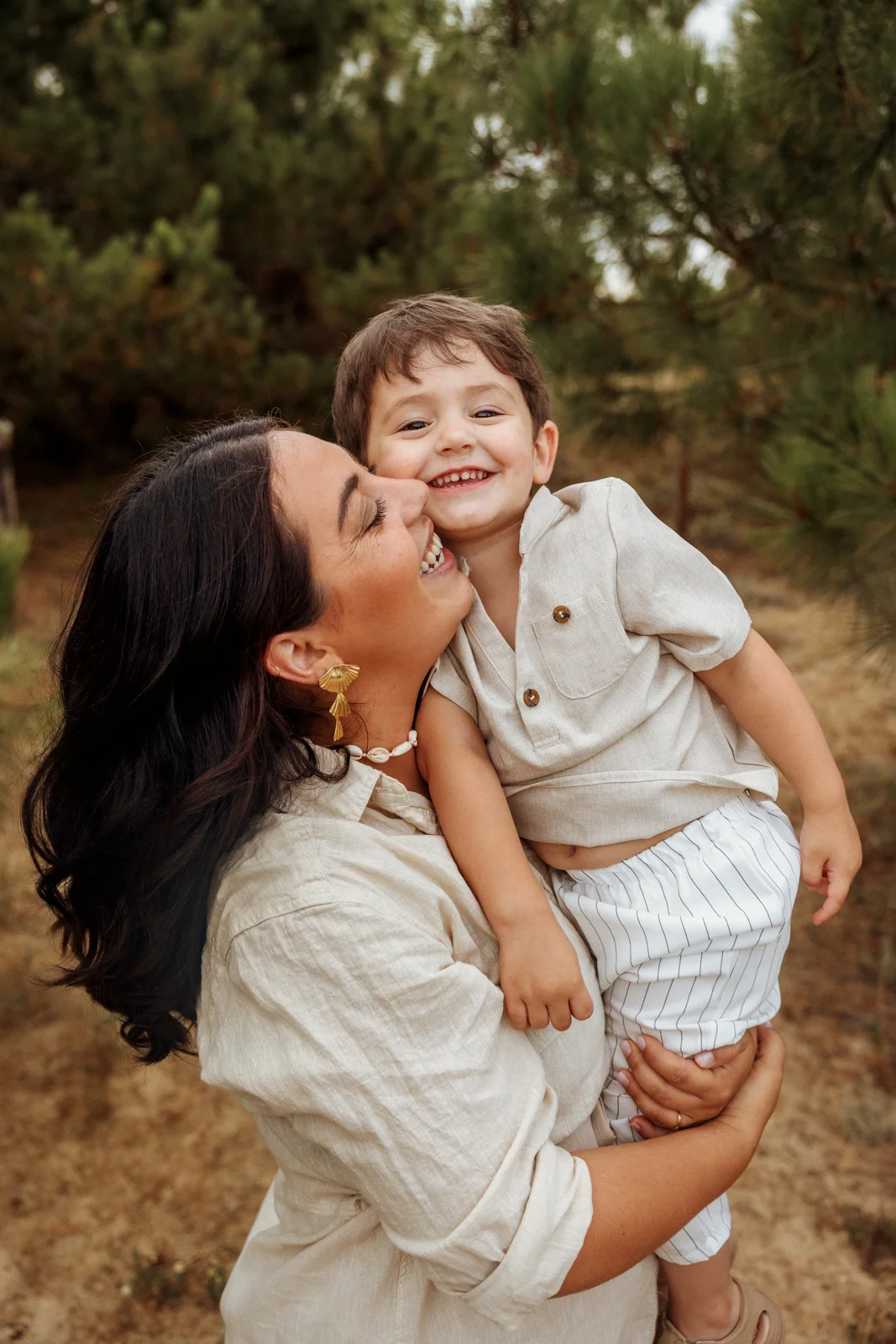 Maman tenant son petit garçon dans les bras pendant une séance photo famille dans les Landes