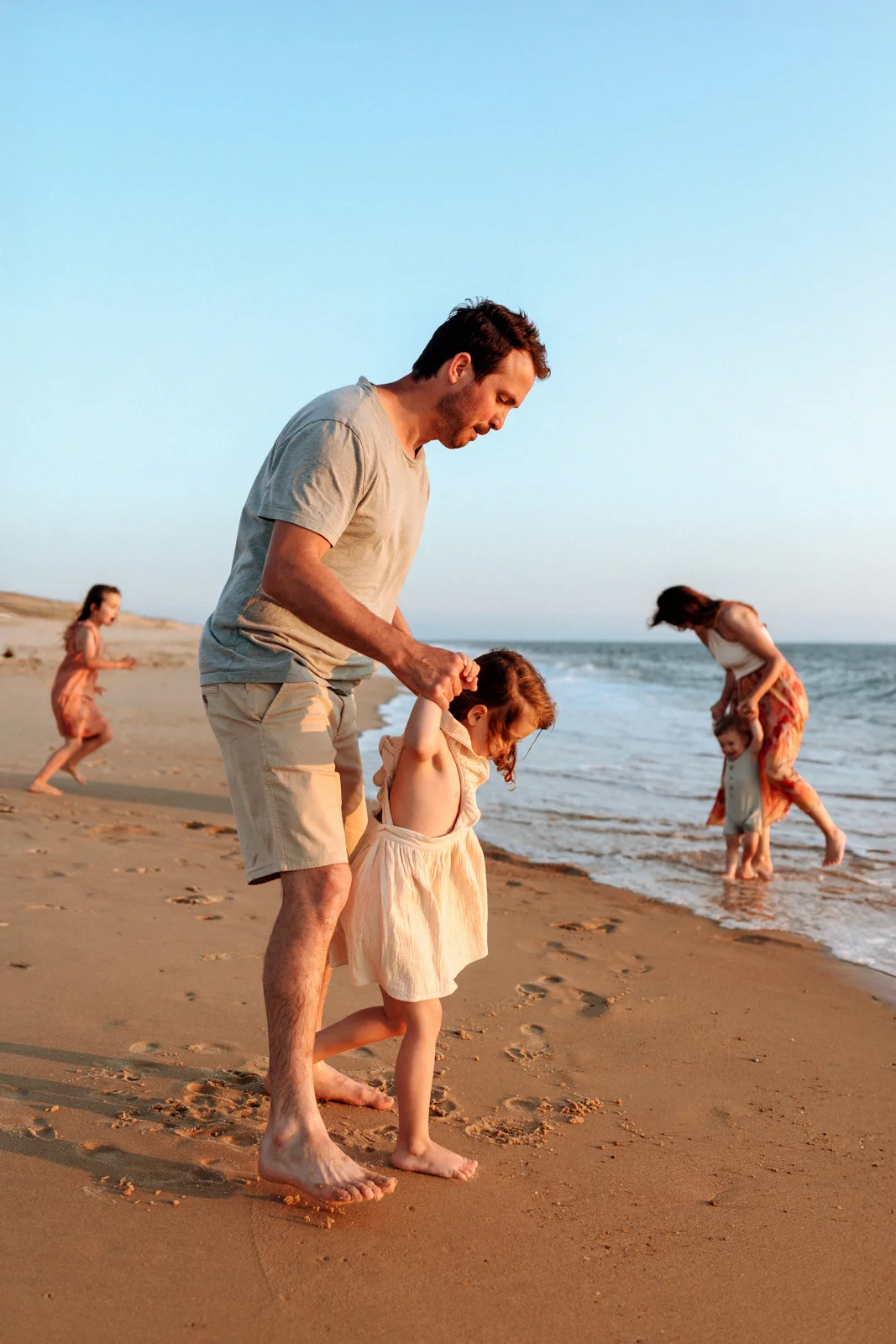 Papa avec sa fille au bord de l’eau en fin de journée pendant une séance photo sur la plage dans les Landes