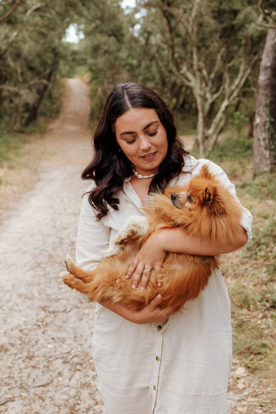 Maman tenant son petit chien dans les bras lors d’une séance photo famille dans les Landes