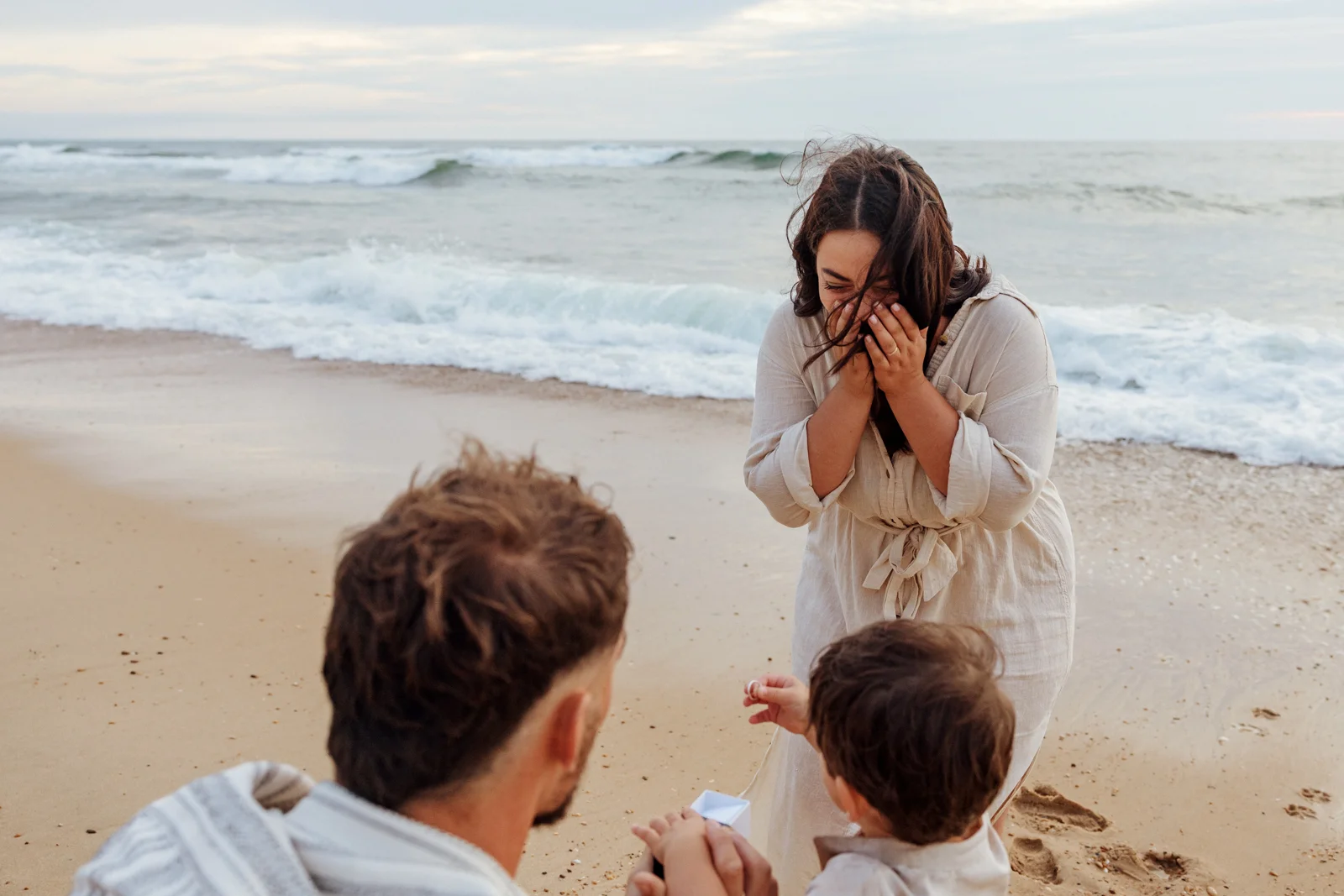 Réaction émue d’une femme lors d’une demande en mariage surprise sur la plage dans les Landes