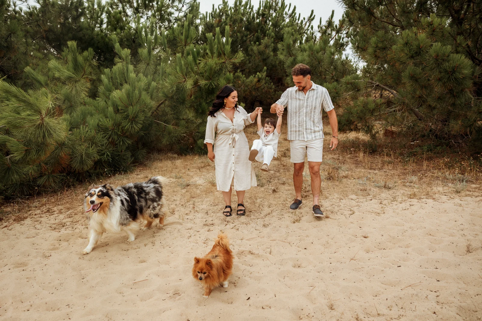 Famille avec un enfant et deux chiens lors d’une séance photo dans la forêt landaise