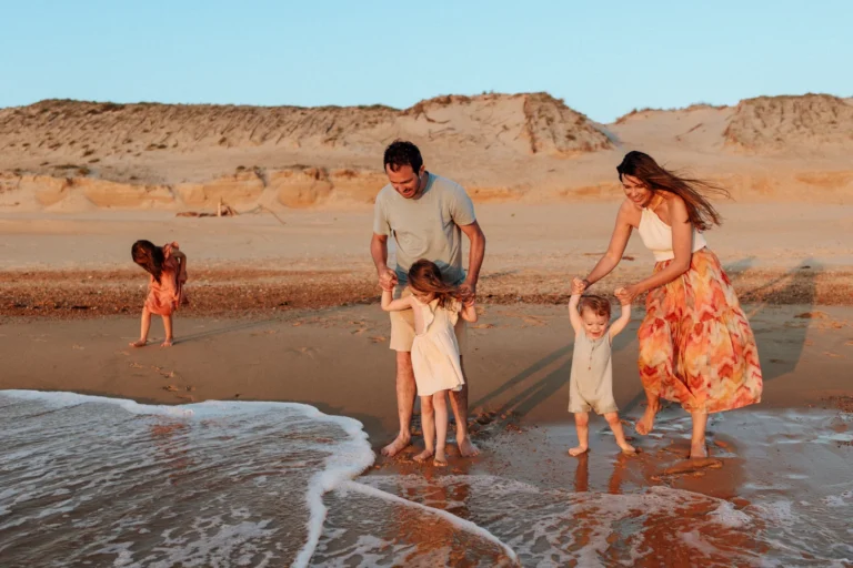 Famille au bord de l’eau au coucher du soleil pendant une séance photo sur la plage dans les Landes