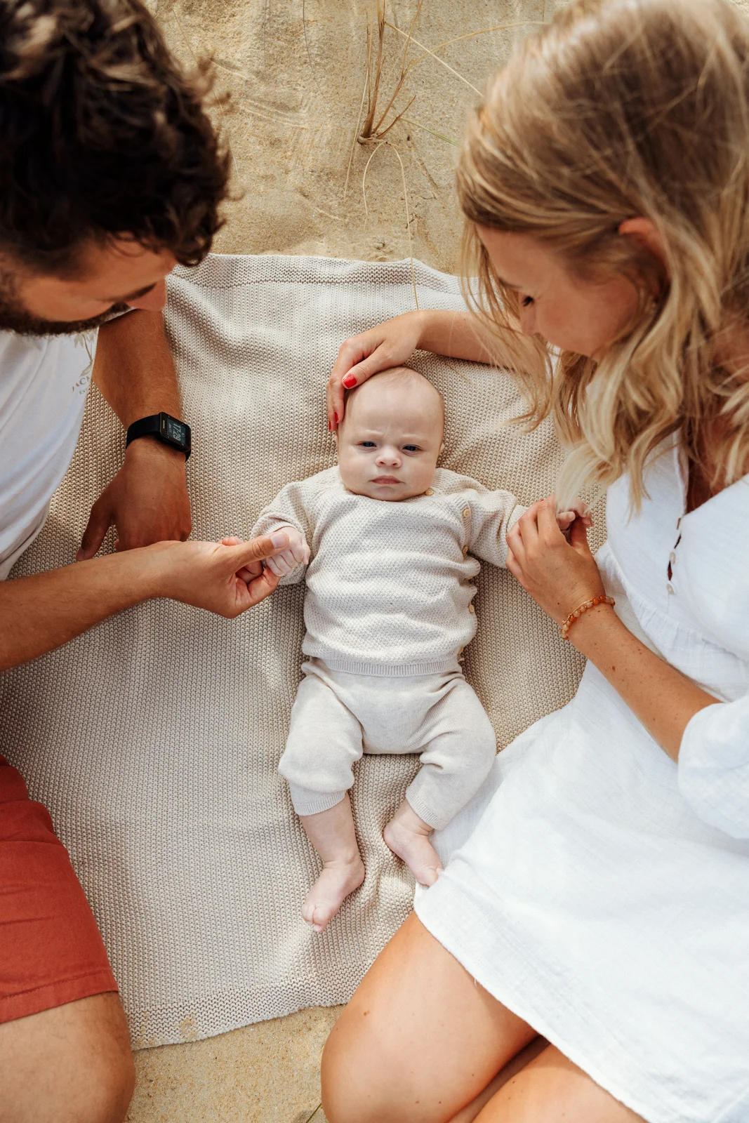 Parents et bébé lors d’une séance photo sur une plage des Landes