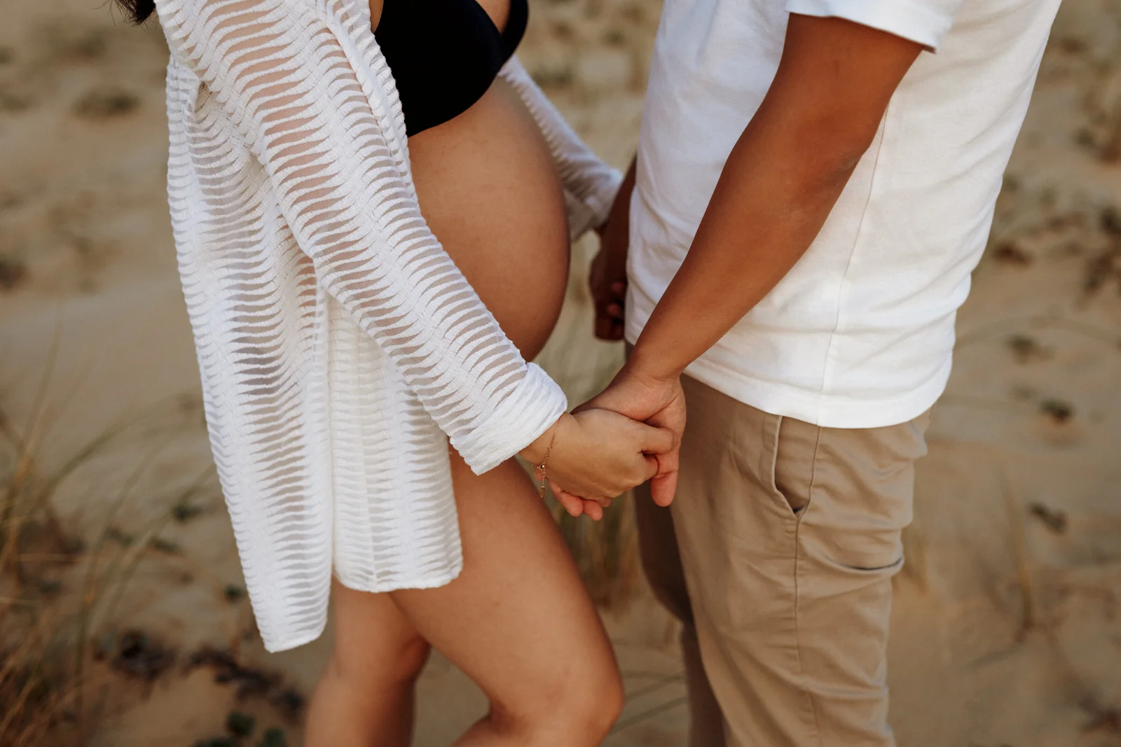 Couple réalisant une séance photo grossesse sur une plage des Landes