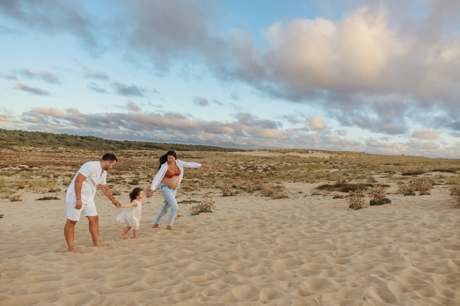 Famille pendant une séance photo grossesse sur une plage des Landes au coucher du soleil