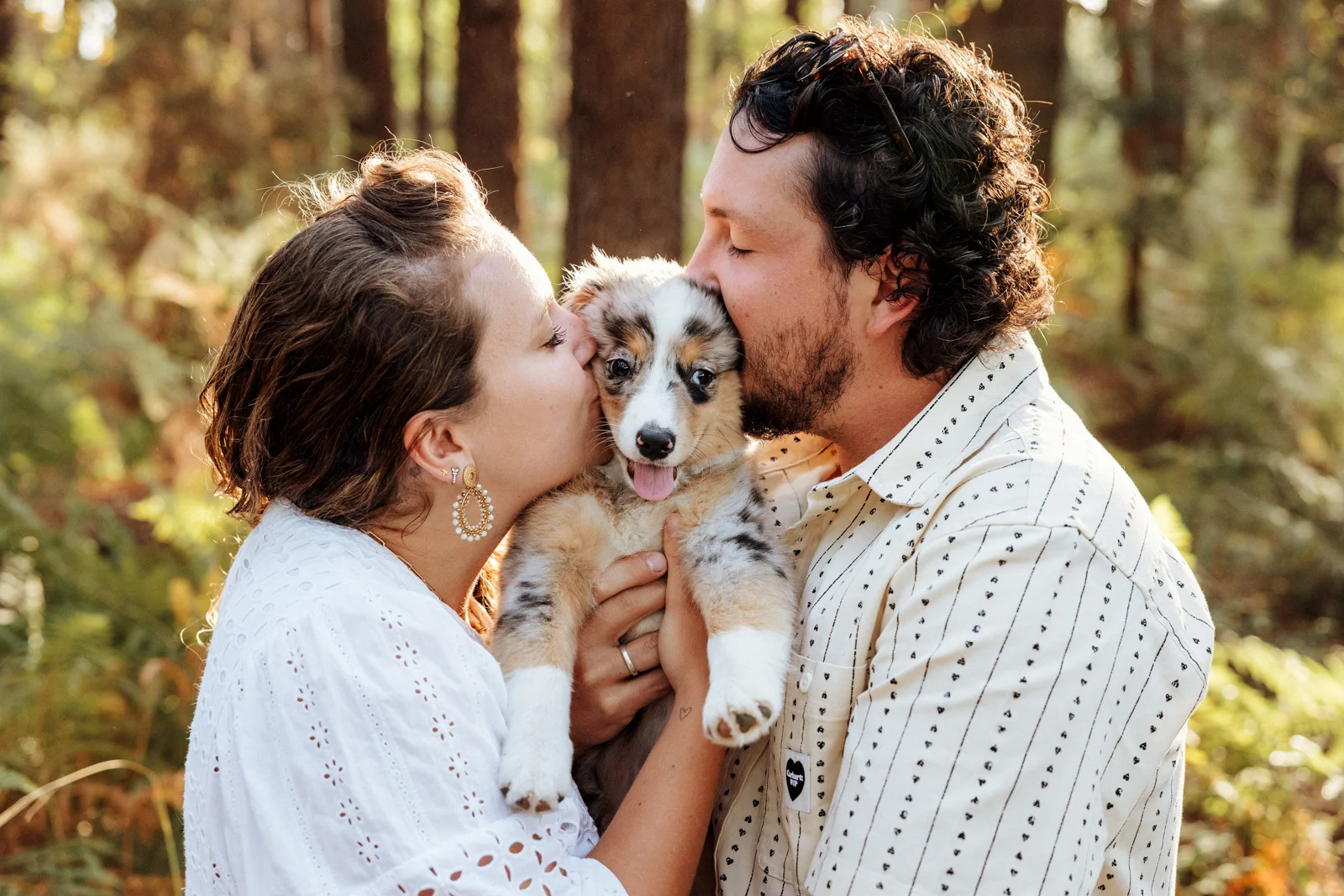 Couple embrassant son chiot berger américain pendant une séance photo dans les Landes