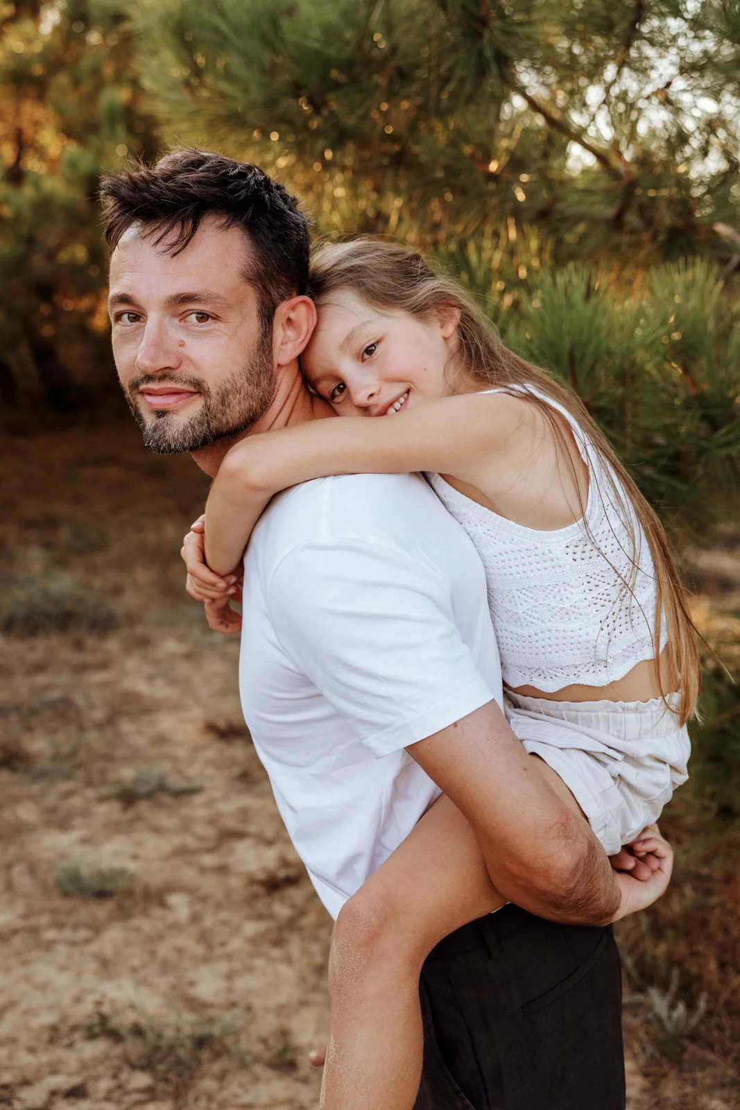 Père portant sa fille dans les bras pendant une séance photo famille dans les Landes