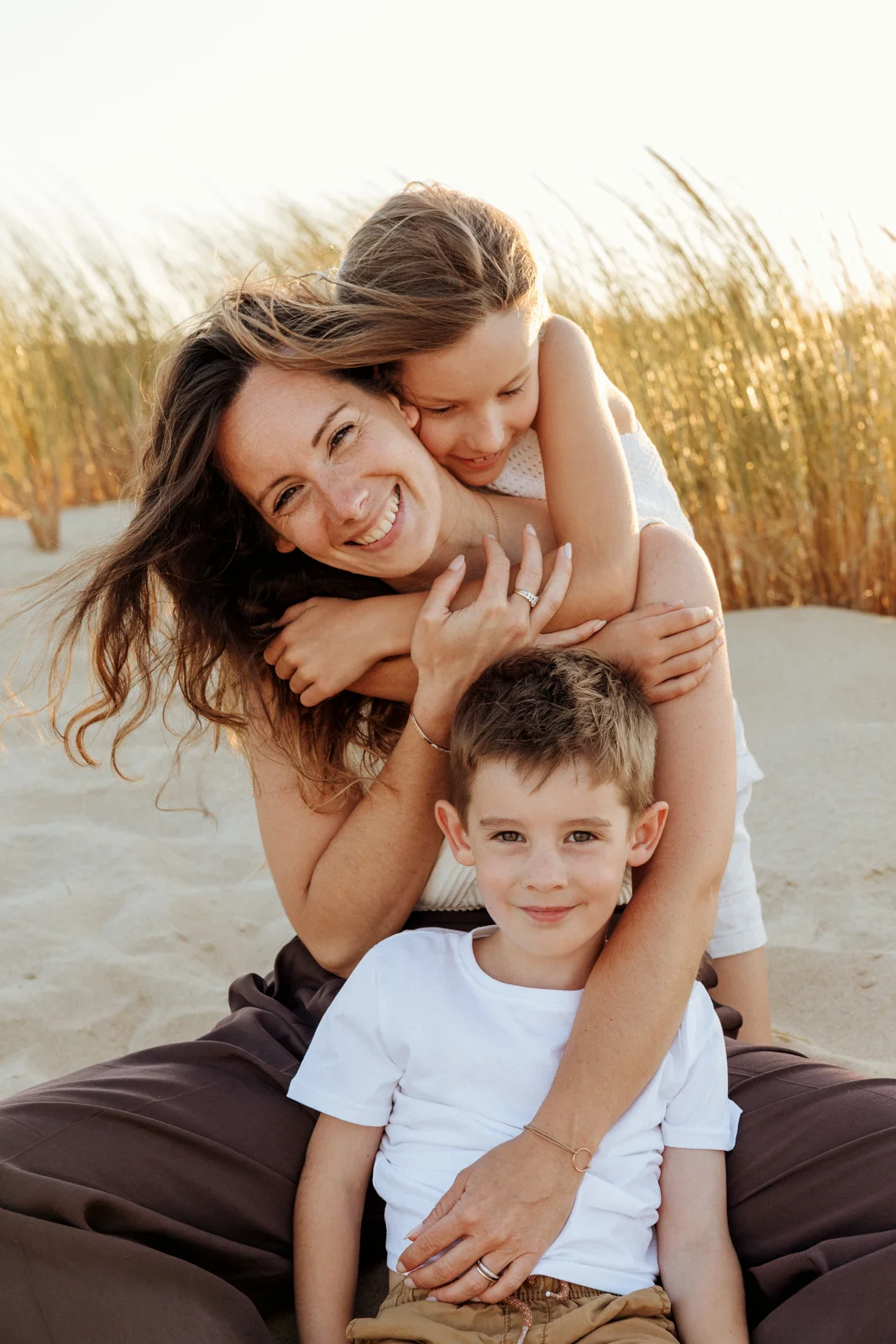 Famille marchant dans les dunes au coucher du soleil lors d'une séance photo près de Messanges