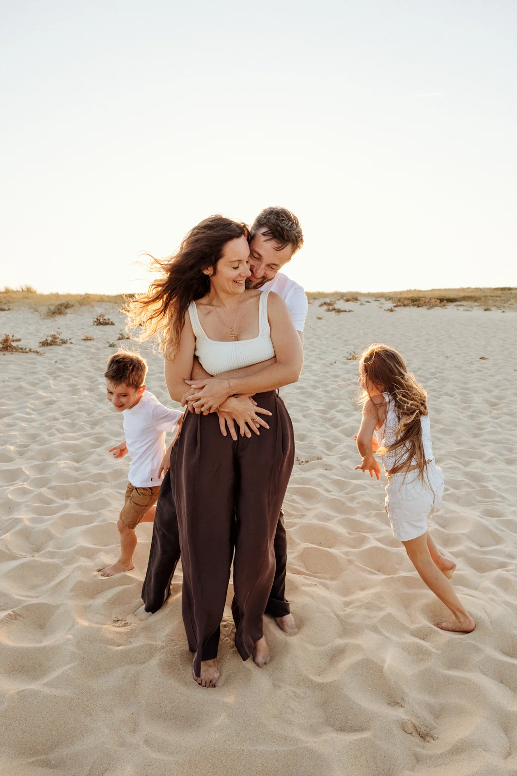 Famille profitant de l'océan au coucher du soleil pendant une séance photo dans les Landes