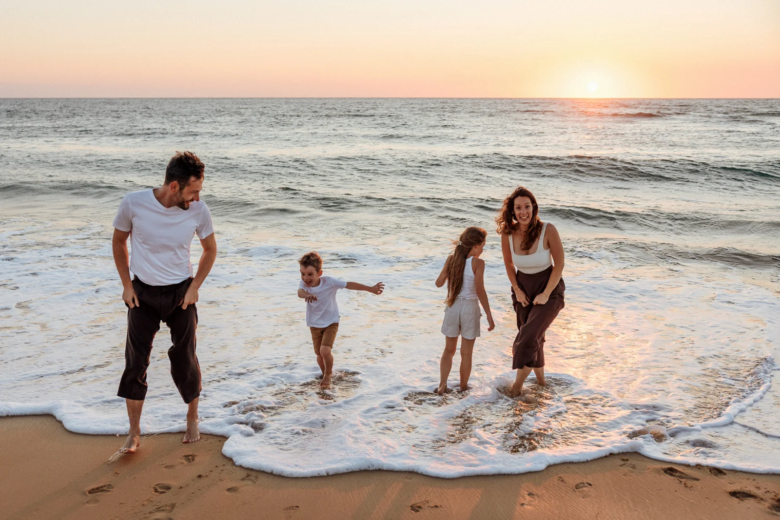 Parents et enfants jouant ensemble dans les dunes pendant leurs vacances dans les Landes