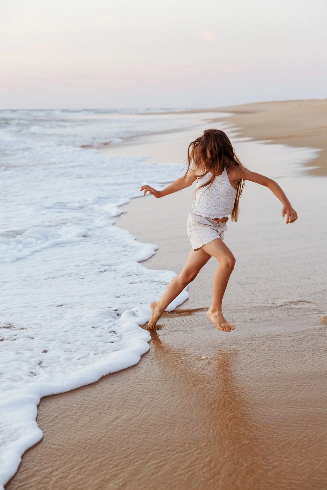 Petite fille jouant au bord de l'eau pendant des vacances dans les Landes