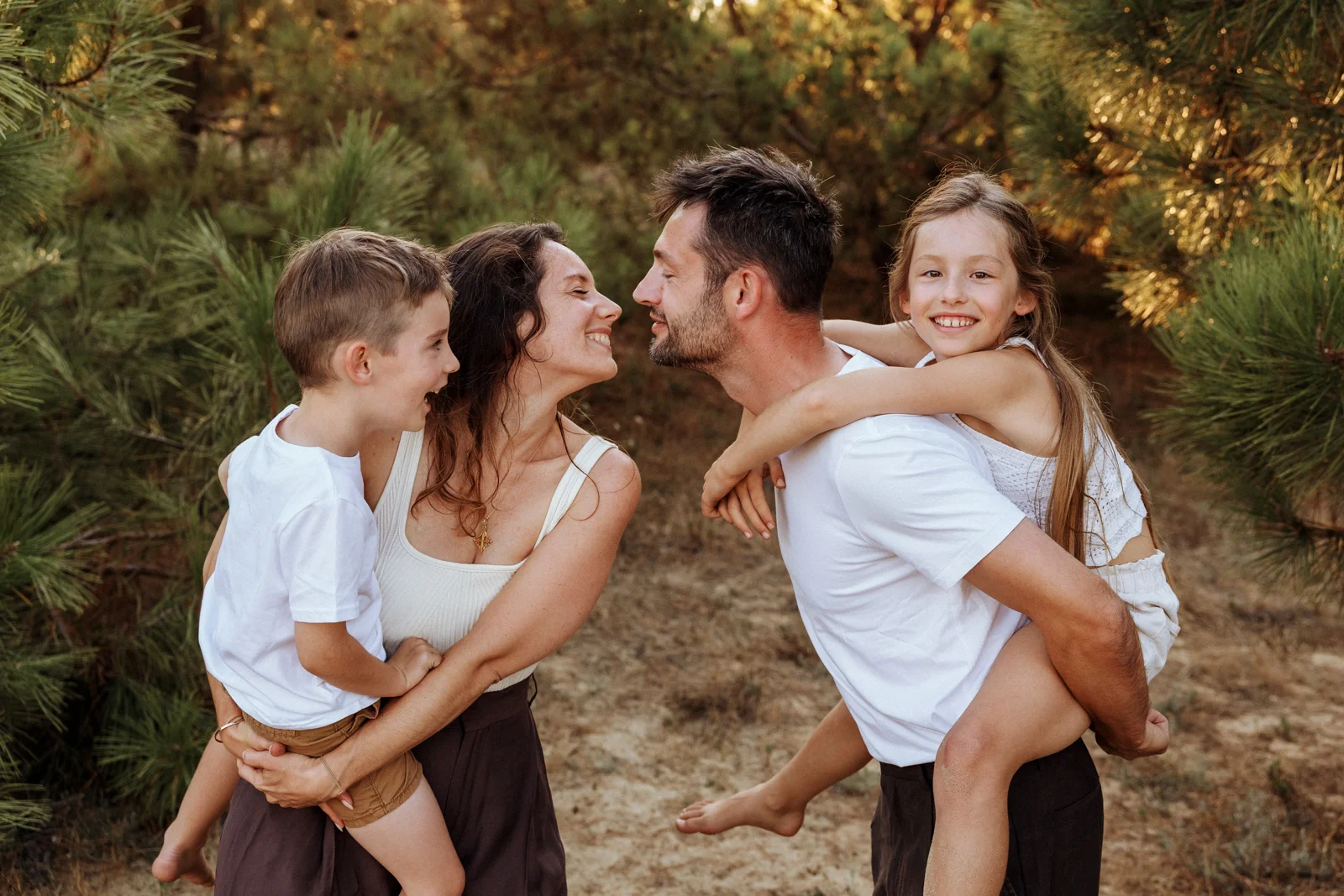 Famille riant ensemble dans les pins lors d'une séance photo de vacances dans les Landes