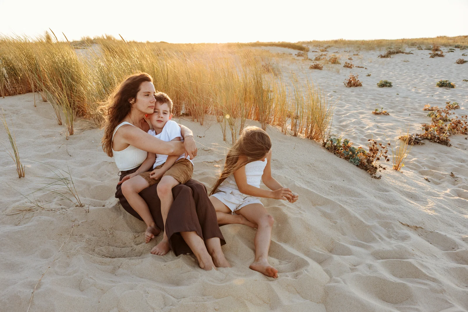 Famille profitant d'un moment ensemble dans les dunes lors d'une séance photo de vacances dans les Landes