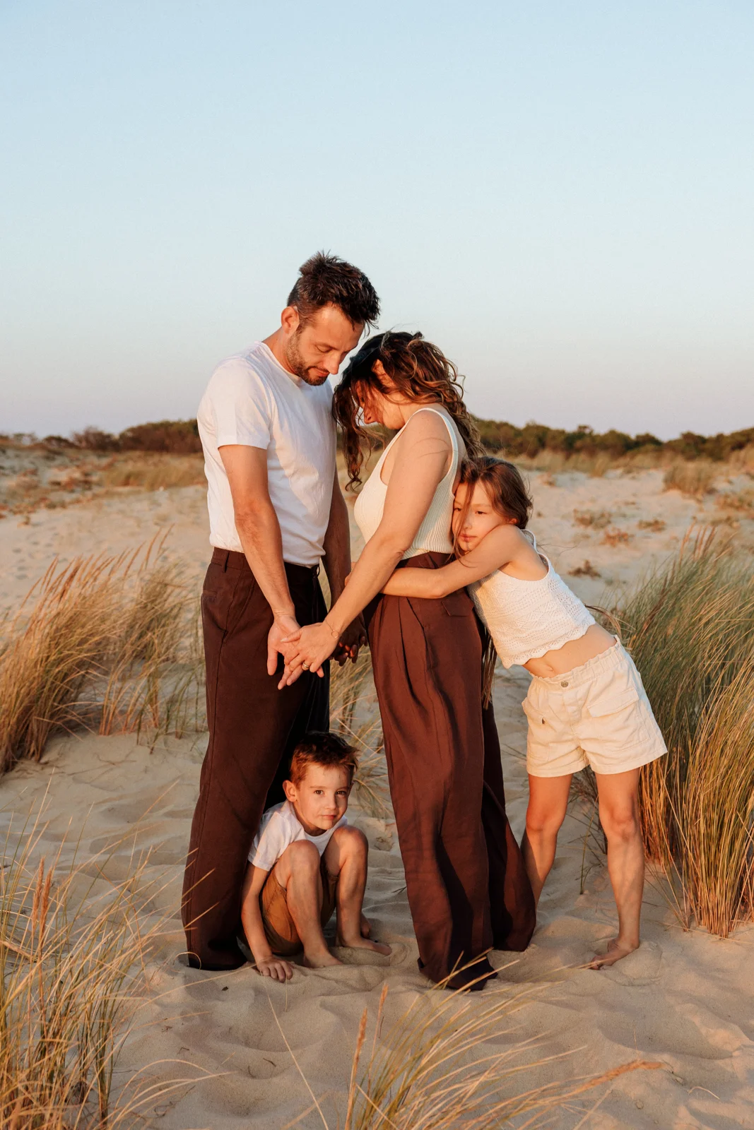 Parents et enfants réunis dans les dunes lors d'une séance photo famille dans les Landes