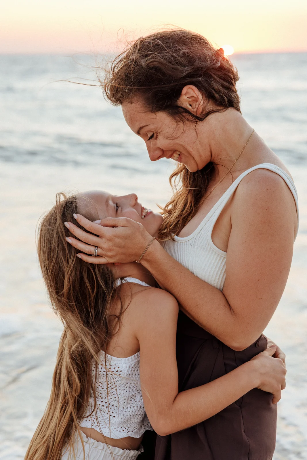 Maman et sa fille partageant un moment de complicité au bord de l'océan dans les Landes