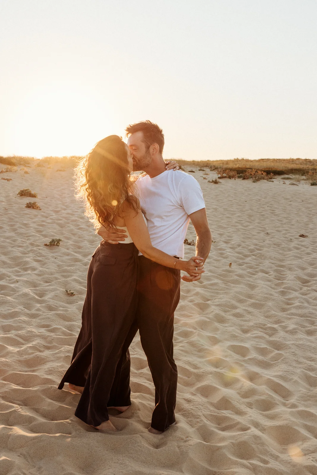 Couple profitant du coucher du soleil dans les dunes pendant une séance photo famille dans les Landes